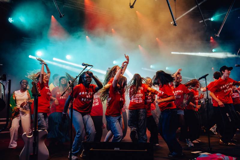 A gospel choir in red shirts singing on the main stage