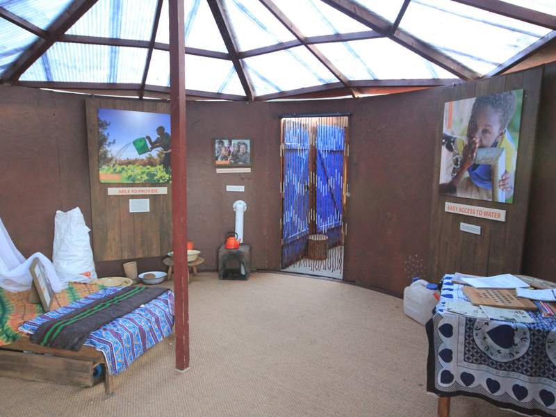 Inside a Journey of Hope hut: a family home recreated with furniture, photos and a World Vision display